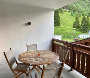 瓦洛西讷Le REFUGE DES PORTES DU MONT BLANC的观景阳台配有一张木桌和椅子。