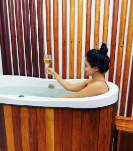 卡莫辛Meditarranee Residence的浴缸里拿着一杯葡萄酒的女人