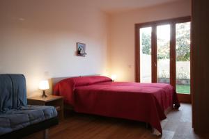 阿西西山谷迪弗朗切斯科酒店的一间卧室设有红色的床和窗户。