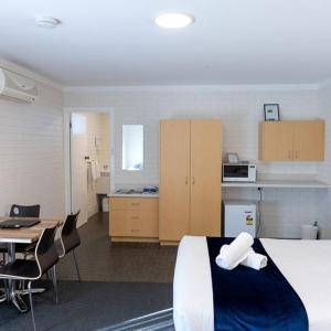 巴瑟尔顿巴瑟尔顿汽车旅馆的客房设有一张床、一张书桌和一间厨房