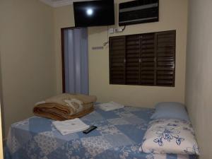 马林加Pousada Catarina的一间卧室配有一张带毯子的床和窗户