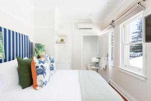棕榈滩Barrenjoey House的白色的卧室设有一张大床和一个窗户