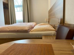 埃森Gasthof & Restaurant "Am Kreuz"的一间卧室配有一张床、一张桌子和一个窗户。