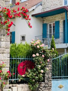 维勒塞瑟尔Manoir Saint-Pierre的一座粉红色花卉和围栏的房子