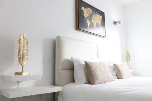 贡多马尔Villarit Porto的卧室配有白色床,墙上挂着植物