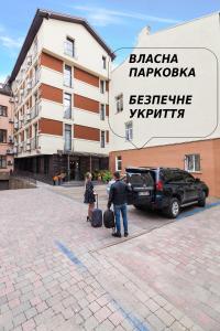 利沃夫埃蒂德酒店的一名男子和一名女子在建筑物前有行李
