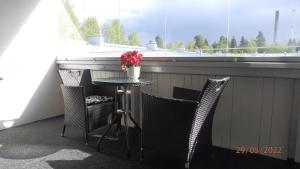 奥卢Gasthouse Oulu的阳台配有桌椅和窗户。