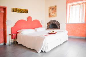 CarascoVilla Paggi Country House的一间卧室配有一张大床和红色床头板