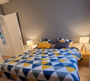 瓦讷APPARTEMENT CHIC EN HYPER CENTRE DE VANNES的卧室配有蓝色和黄色的被子。