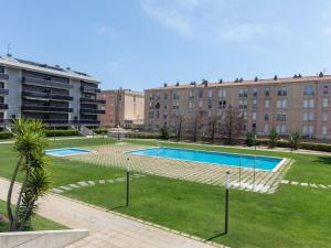 圣安东尼奥·德·卡隆Apartment El Jardi del Mar的建筑物前公园内的游泳池