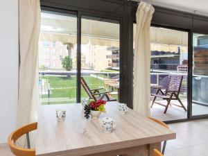 圣安东尼奥·德·卡隆Apartment El Jardi del Mar的带窗户的客房内的一张带鲜花的木桌