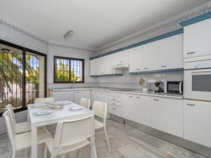米哈斯科斯塔Villa Querida by Interhome的厨房配有白色橱柜和桌椅