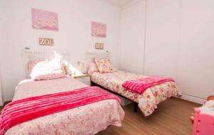托罗克斯Villa Torre Paraíso的小客房内的两张床和粉红色床单