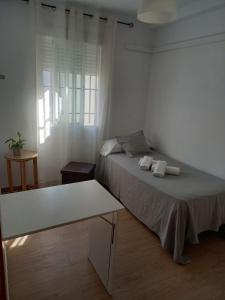 塞维利亚塞维利亚韦尔耶罗旅馆的白色的客房配有一张床和一张桌子