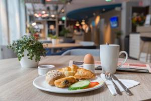 布鲁塞尔Holiday Inn Express Brussels-Grand-Place, an IHG Hotel的桌上放着一盘羊角面包和鸡蛋