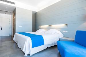 拉斯内格拉斯卡拉格兰德卡博德佳塔水疗酒店的一间卧室配有一张大床和一张蓝色椅子
