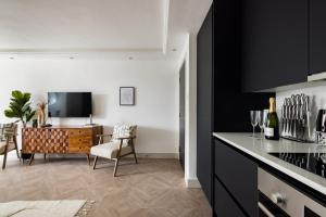 伦敦The Battersea Flat - Exquisite 2BDR Flat with Terrace的一间厨房,配有黑色橱柜和用餐室