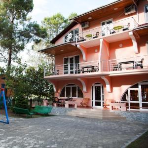 谢赫维蒂利Hotel "Qeti"的粉红色的建筑,前面有一个游乐场
