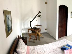 伊瓜佩Pousada Atelier Aly da Costa的一间卧室配有一张床、一把椅子和一张桌子