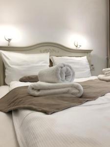 VăleniPensiunea ARMONIA的床上铺有白色毛巾的床