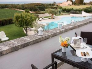 滨海波利尼亚诺Borgobianco Resort & Spa – MGallery Hotel Collection的一张桌子,上面有食物,放在游泳池边