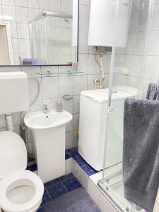 斯科普里Cosy Apartment on an amazing location!的白色的浴室设有卫生间和水槽。