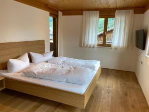 施科佩尔瑙Haus Emma的一间卧室配有一张带白色床单的床和一扇窗户。