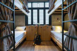 胡志明市9 Hostel and Bar的客房设有两张双层床和吉他