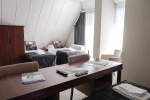 奥多恩Hotel De Oringer Marke & Stee by Flow的一间设有两张床和一张桌子的房间
