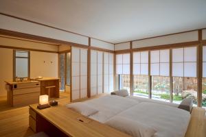 尾道市Azumi Setoda的卧室配有一张床、一张书桌和窗户。