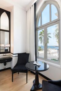 KonakEN Hotel Boutique Izmir的一间带桌子的客厅,享有海滩美景