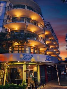 阳光海滩尤利酒店的一座高大的建筑,晚上有灯光的外墙