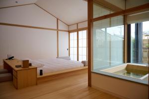 尾道市Azumi Setoda的卧室设有一张床和一个靠窗的浴缸