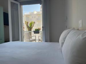 利尼亚诺萨比亚多罗雅典娜酒店 的卧室设有白色的床和大窗户