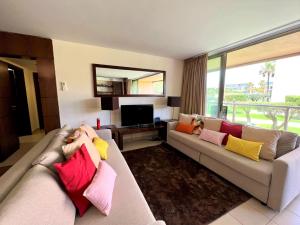 吉亚Albufeira Salgados Premium 1 With Pool by Homing的客厅配有带色彩缤纷枕头的沙发