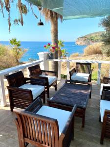阿拉尼亚ZBB Stylish Villa & Bungalows的一组木凳坐在俯瞰着大海的庭院