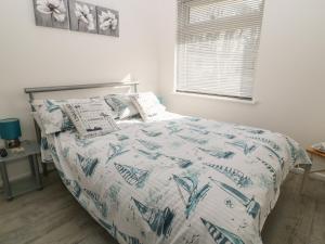 利斯卡德Ballasalla的一间卧室配有一张带蓝色和白色棉被的床