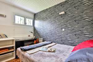塔尔诺斯La Presque Basque的一间卧室配有带图案的墙壁和一张床