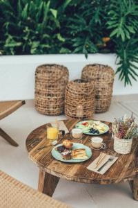 坎佩略Cala Lanuza Suites的一张木桌,上面放着食物盘