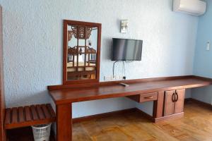 达累斯萨拉姆Serene Beach Resort的客房设有带镜子的桌子和电视
