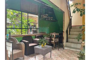 长滩岛OYO 876 Escurel Inn Boracay的一间设有桌椅和绿色墙壁的客房