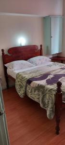 丰沙尔Residencial Monaco的一间卧室配有一张大床和木制床头板
