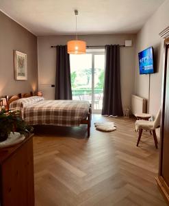 卢里西亚HOTEL LE FONTI的一间卧室设有一张床和一个滑动玻璃门