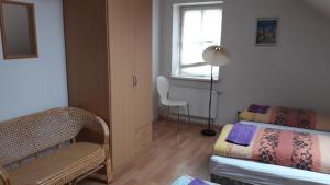 洛沃西采Ubytovací zařízení的一间卧室设有一张床、一个窗口和一把椅子