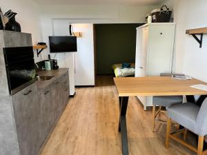 KlaaswaalB&B de Danser的厨房配有桌子和书桌及电视
