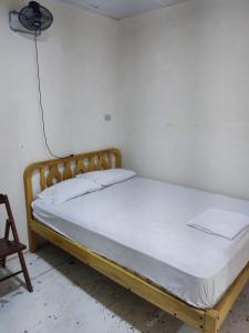 萨利纳斯Alquiler de habitaciones BAY HOUSE HOSTEL的一张位于白色墙壁的房间的床