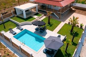 VergiaVilla Liana , private Villa with pool and garden的享有房子的空中景色,设有一座带遮阳伞的游泳池