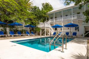 基韦斯特325号宾馆的一个带蓝色椅子和遮阳伞的游泳池