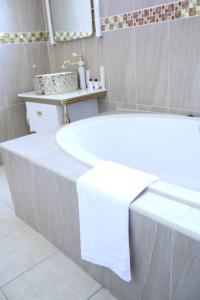 姆巴巴内Open House Hotel的浴室内设有一个白色浴缸