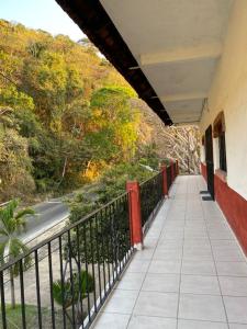 巴亚尔塔港Traditional Sierra Leon Oceanfront Rooms - Adults Only的带有栅栏和道路的建筑的阳台